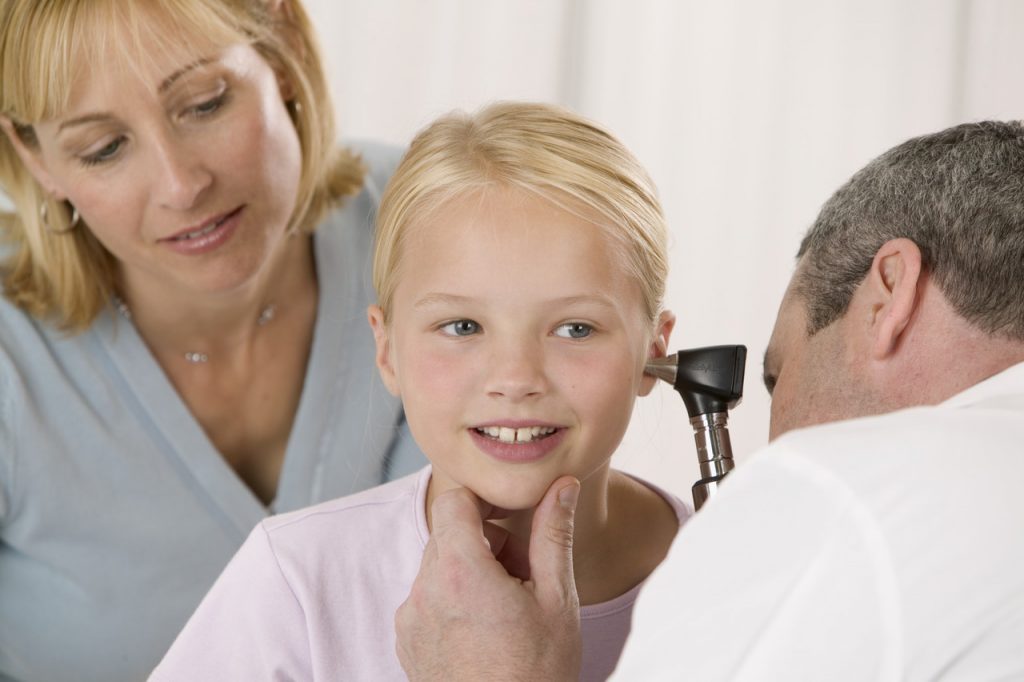 a doctor examining a child's ear